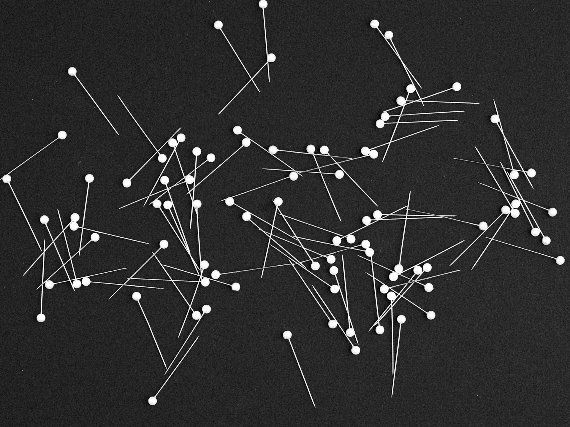 Scattered pins on a black background