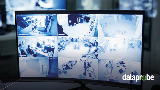 A curved computer monitor displaying a 16-panel security camera feed in blue-tinted monochrome, with a 'dataprobe' watermark in the lower right corner.