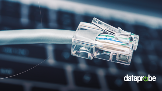 A close-up of a clear RJ45 Ethernet connector on a gray cable, with a blurred computer keyboard in the background and the 'dataprobe' logo in the bottom right corner.