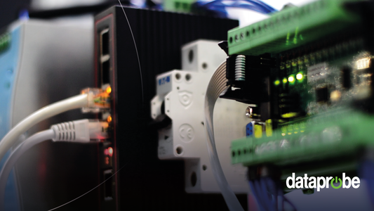 Close-up of a data acquisition or networking setup with a black industrial module, white connector, Ethernet cable, and green circuit boards, featuring a 'dataprobe' watermark in the lower right.