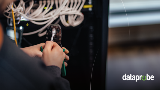 A close-up of a person using a crimping tool on an Ethernet cable in front of a server rack, with the 'dataprobe' logo in the bottom right corner.